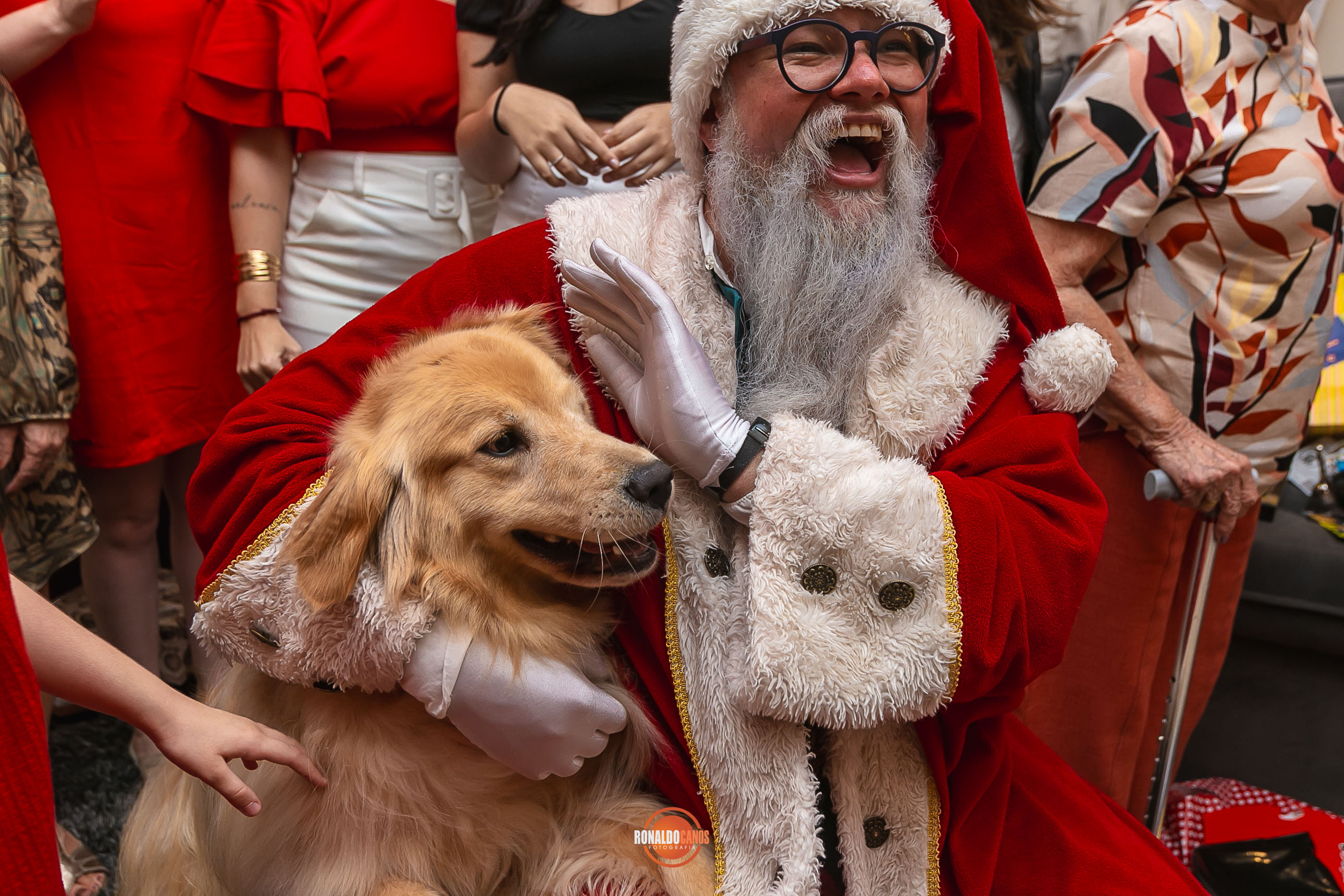 Menino abraçando o Papai Noel com carinho, sentado em seu colo