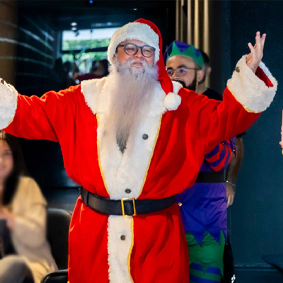 Papai Noel de braços abertos, em pose alegre de estúdio